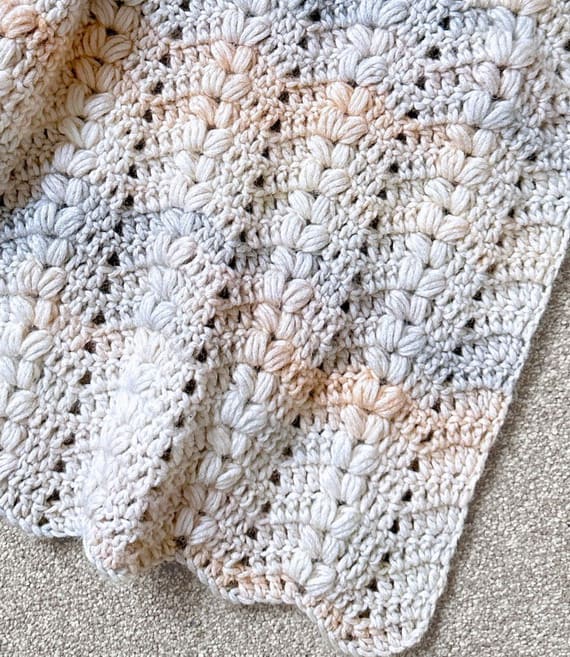 This crochet ripple blanket combines soft hues with a touch of texture, making it both soothing and visually interesting. Puff stitches add dimension, forming patterns reminiscent of wheat swaying in a gentle breeze. Ideal for bedrooms or nurseries, it introduces warmth without overpowering the space.